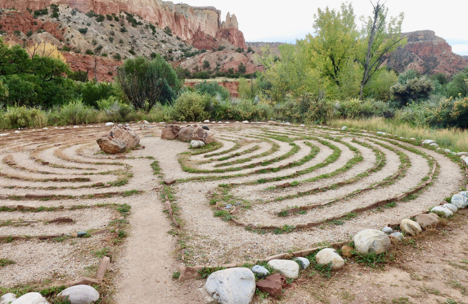 Desert labyrinth with rock formations and trees.