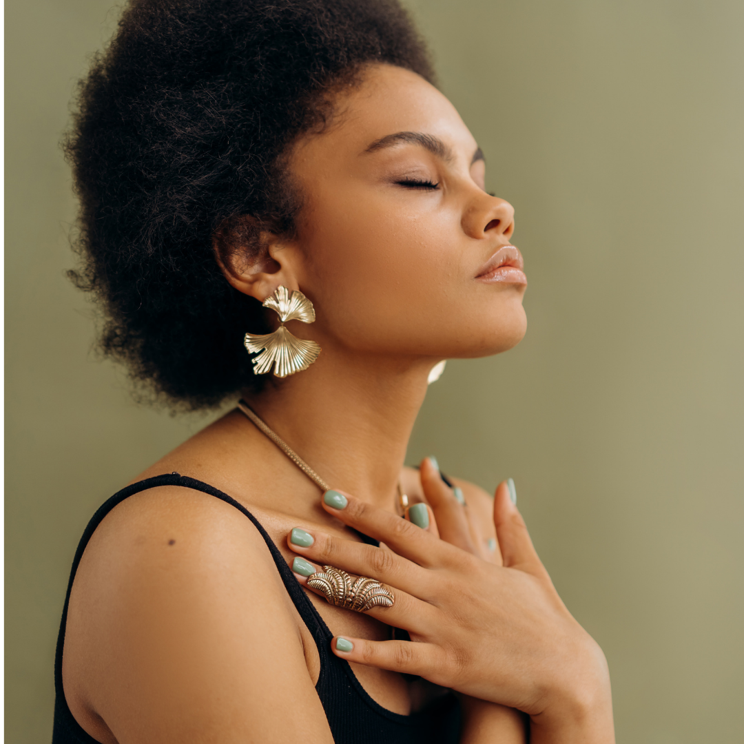 Woman wearing gold earrings with closed eyes