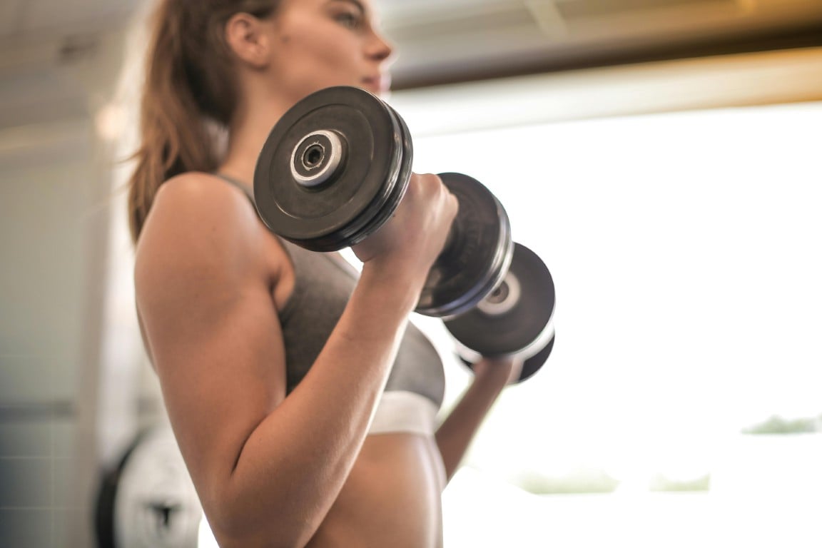 Woman lifting dumbbells in gym