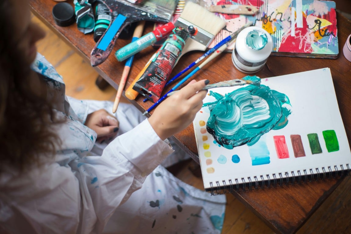 Artist painting with brushes and vibrant colors