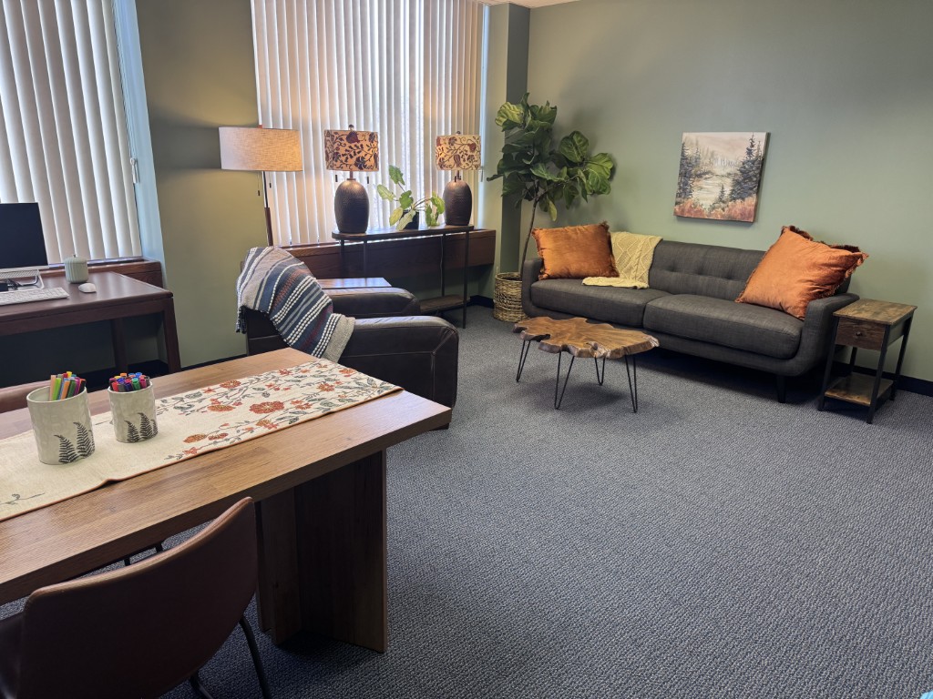 Cozy office with couch, desk, and natural light