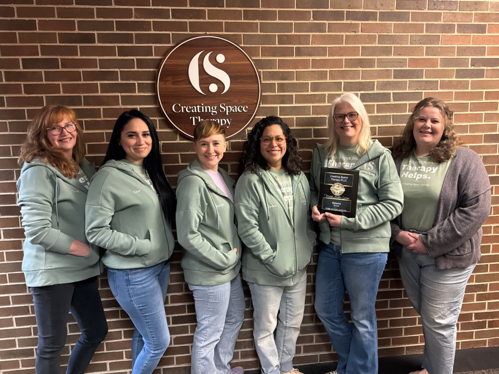 Creating Space Therapy team standing against a brick wall with the founder holding The Best Mental Health Service in Batavia award.